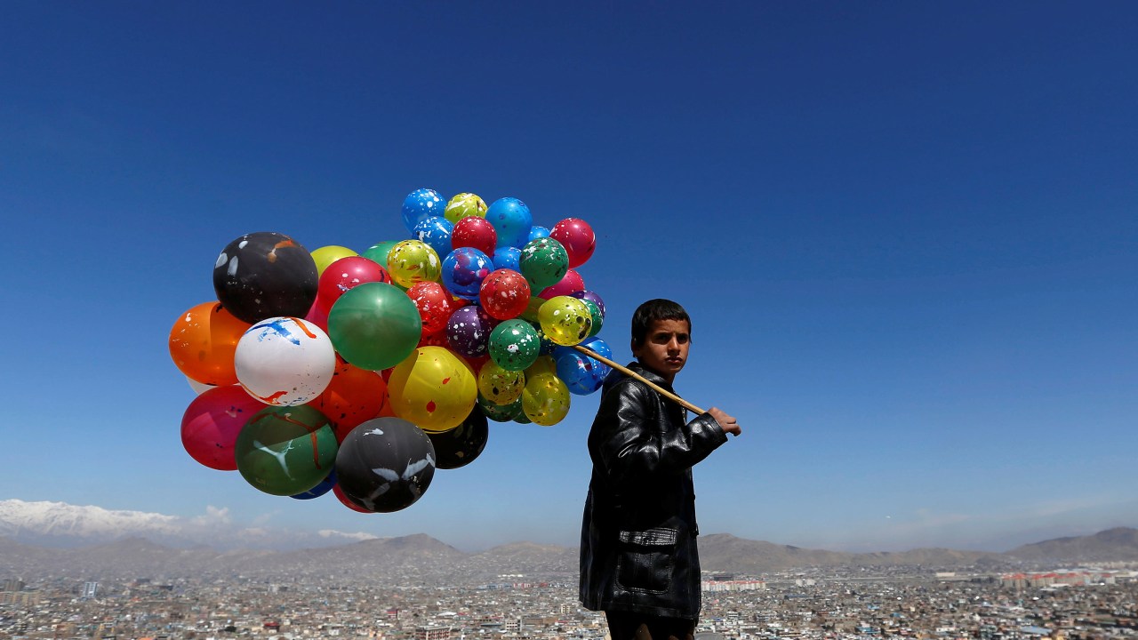 Imagens do dia - Menino vende balões em Cabul, no Afeganistão