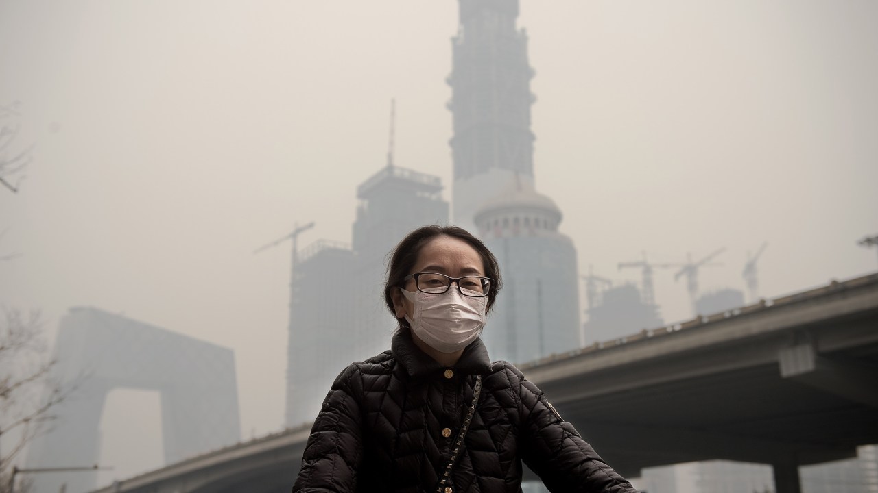 Imagens do dia - Chineses usam máscara para se proteger da poluição do ar