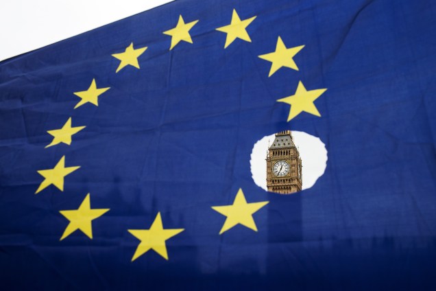 Manifestante ergue uma bandeira da União Europeia com uma das estrelas simbolicamente retirada em frente às Casas do Parlamento logo após a primeira-ministra Theresa May iniciar formalmente a saída do Reino Unido do bloco - 29/03/2017