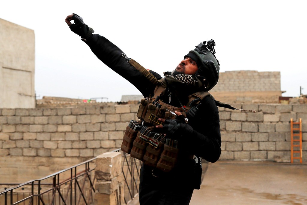 Imagens do dia- Soldado iraquiano joga granada durante confronto com o Estado Islâmico em Mossul, Iraque - 02/03/2017