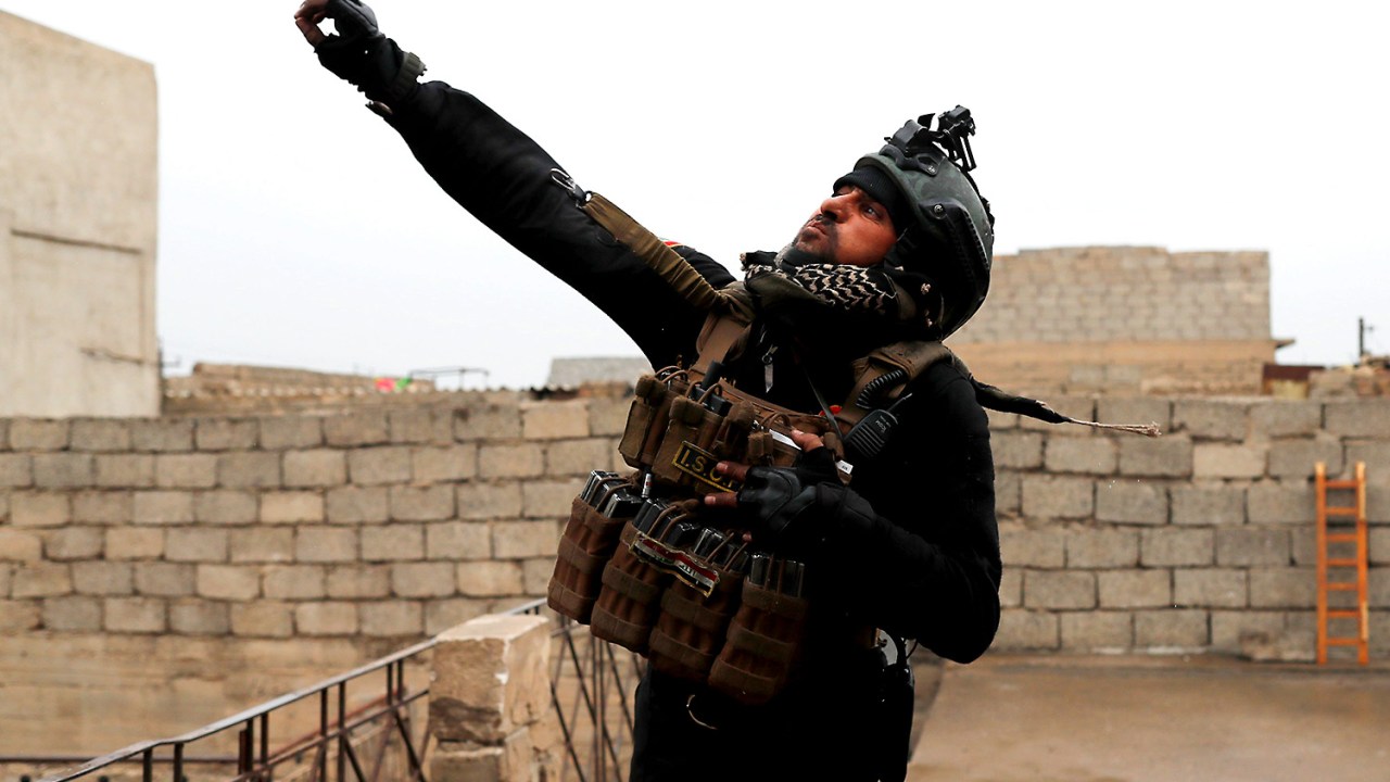 Imagens do dia- Soldado iraquiano joga granada durante confronto com o Estado Islâmico em Mossul, Iraque - 02/03/2017