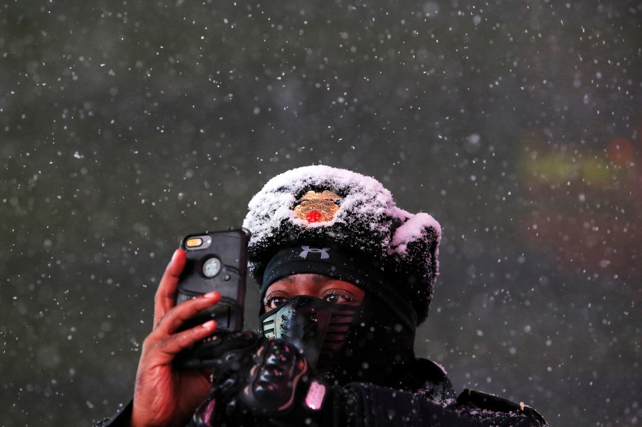 Sargento da segurança pública de Times Square, tira fotos durante nevasca em Nova York, 14/03/2017