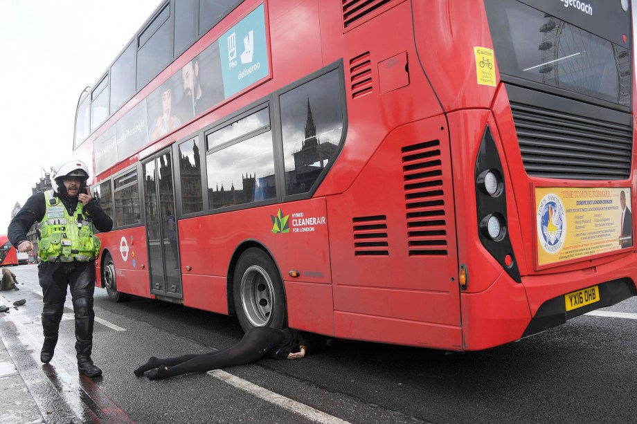 Mulher fica debaixo de um ônibus após incidente com tiros no Parlamento inglês na ponte de Westminster em Londres - 22/03/2017