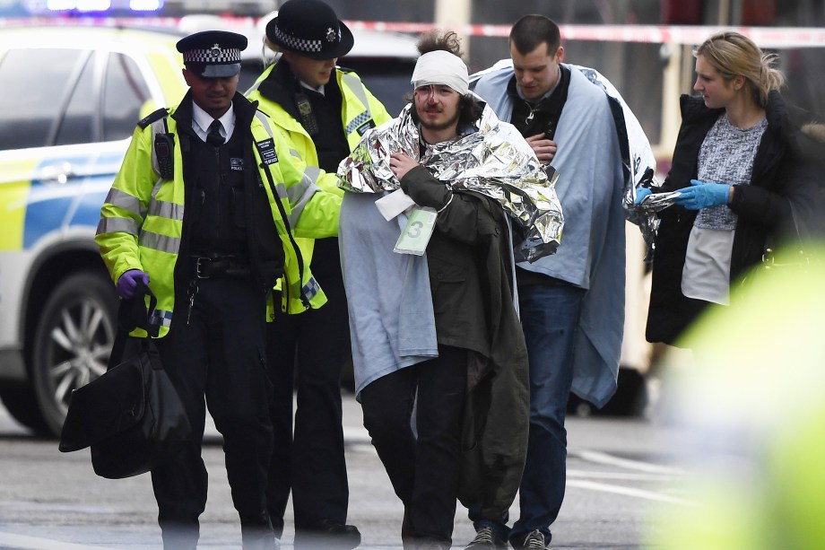 Homem ferido recebe atendimento após incidente com tiros nos arredores do Parlamento, na ponte de Westminster em Londres - 22/03/2017