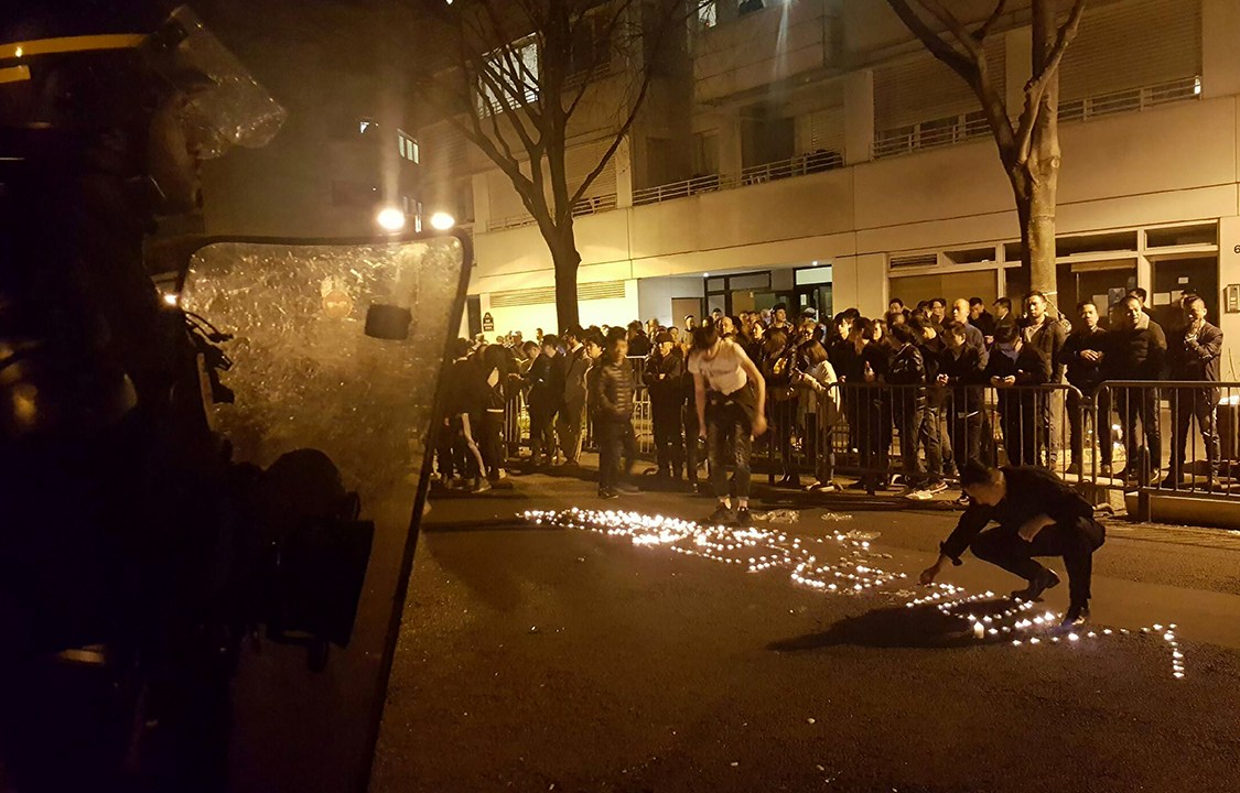 Manifestantes acendem velas no formato da palavra "Violence", protestando contra assassinato de imigrante chinês em Paris