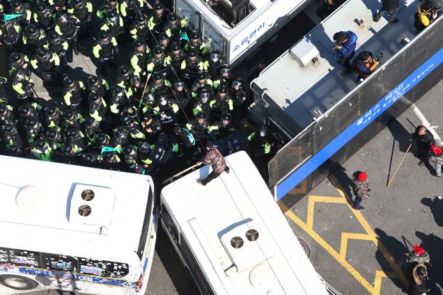 Manifestante desafia polícia subindo em cima de uma van, durante protesto na Coreia do Sul, em apoio a presidente afastada, Park Geun-hye
