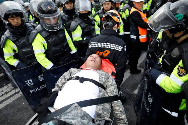 Manifestante é ferido e retirado ferido do protesto em apoio a presidente afastada da Coreia do Sul, Park Geun-hye, em Seul