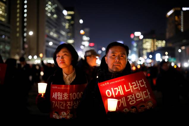 Manifestantes protestam contra a presidente Park Geun-hye, na Coreia do Sul, com cartazes que dizem "Essa é a nossa nação, isso é justiça"