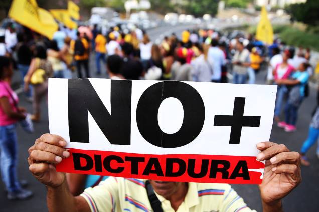 Manifestante segura cartaz com a mensagem ‘Não mais ditadura’ em protesto contra o presidente Nicolas Maduro, em uma rodovia de Caracas - 31/03/2017