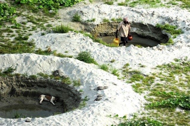 Fazendeiro coleta água para irrigação da sua plantação de pepinos próxima ao rio Ganges, em Allahabad, Índia - 21/04/2017