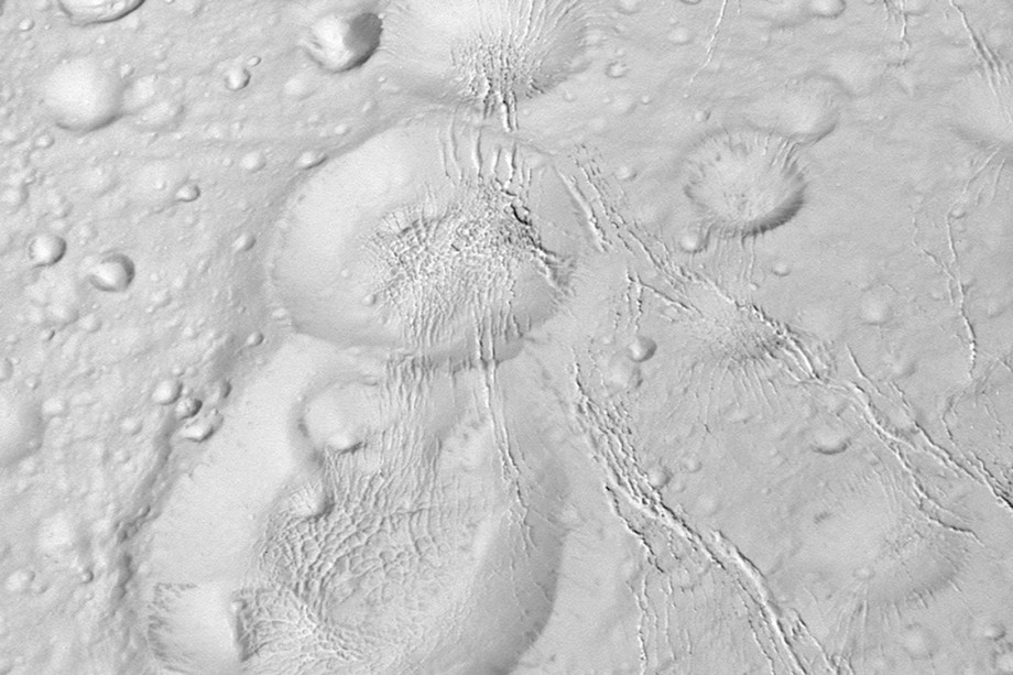 A sonda Cassini da Nasa mostra as crateras da lua Enceladus de Saturno durante voo rasante