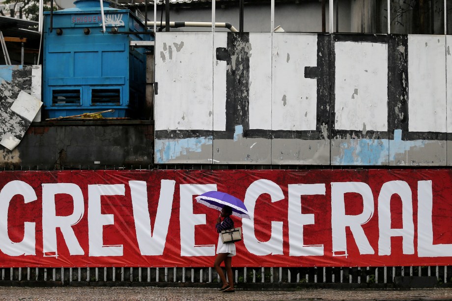 Mulher passa por uma faixa escrita 'Greve Geral' durante dia de manifestações contrárias às reformas propostas pelo governo Michel Temer no Rio de Janeiro - 28/04/2017