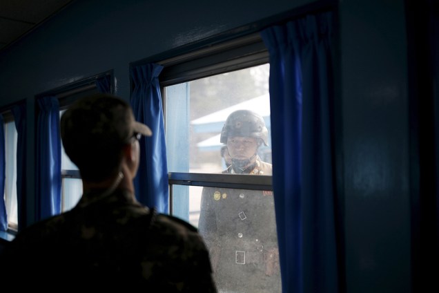 Um soldado sul-coreano e um norte-coreano se encaram pela janela de uma sala de conferência da Comissão de Armistício Militar do Comando das Nações Unidas em Panmunjom, Coreia do Sul - 30/03/2016