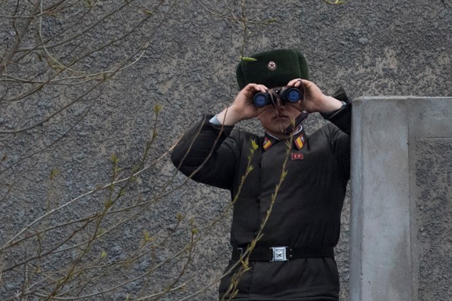 Soldado norte-coreano usa binóculos na fronteira com a China no rio Yalu, próximo a cidade Sinuiju, na Coreia do Norte, e de Dandong, China - 01/05/2014