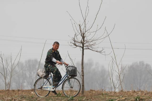 Soldado norte-coreano anda de bicicleta próximo ao rio Yalu, que faz fronteira com a China - 15/04/2017