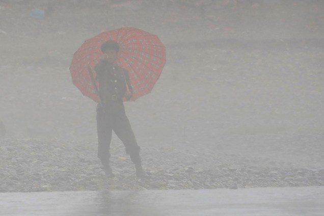 Em um dia chuvoso, soldado norte-coreano guarda a fronteira com a China no rio Yalu, próximo a cidade Sinuiju, na Coreia do Norte, e de Dandong, China - 17/04/2017