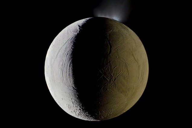 Enceladus, uma das luas de Saturno, lança vapor d'água no espaço. Mosaico feito com imagens da sonda Cassini, em dezembro de 2009
