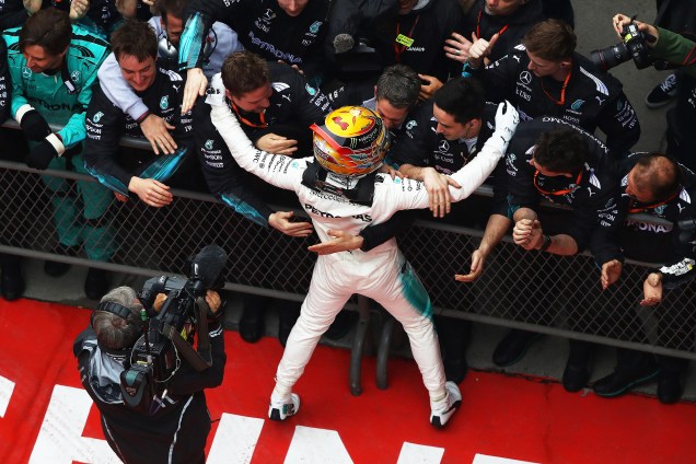 O piloto britânico Lewis Hamilton, festeja com os companheiros da equipe Mercedes após vitória no Grande Prêmio da China - 09/04/2017