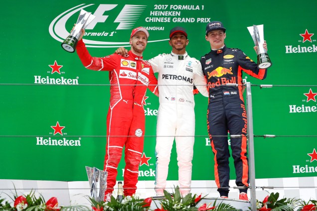 O piloto britânico da Mercedes Lewis Hamilton, festeja no pódio ao lado do alemão Sebastian Vettel da Ferrari e do holandês Max Verstappen da Red Bull - 09/04/2017