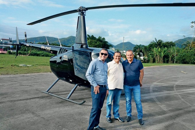 “ONÇA” – Euripedes Junior (à dir.) e o helicóptero do Pros: política, negócios e fortuna