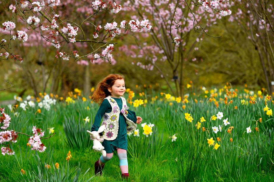 Garotinha corre em um campo de flores em um festival no Kew Gardens, em Londres