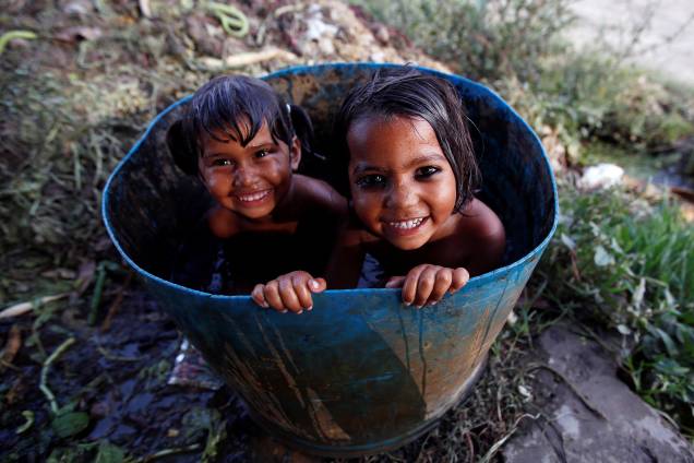 Crianças se divertem enquanto tomam banho dentro de uma bacia em um dia quente na cidade de Nova Déli, na India - 18/04/2017