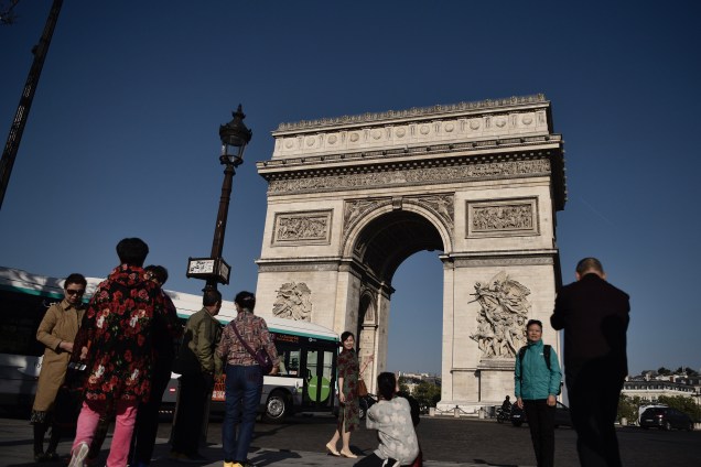 Turistas tiram fotos na Champs Élysées perto do Arco do Triunfo, em Paris, um dia depois que um atirador abriu fogo e matou um policial em ataque reivindicado pelo Estado Islâmico - 21/04/2017