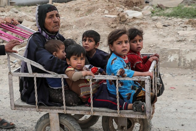 Mulher e crianças deslocadas são transportados em carrinho na tentativa de fugir das áreas de conflito entre forças de segurança do Iraque e jihadistas do Estado Islâmico em Mosul - 24/04/2017