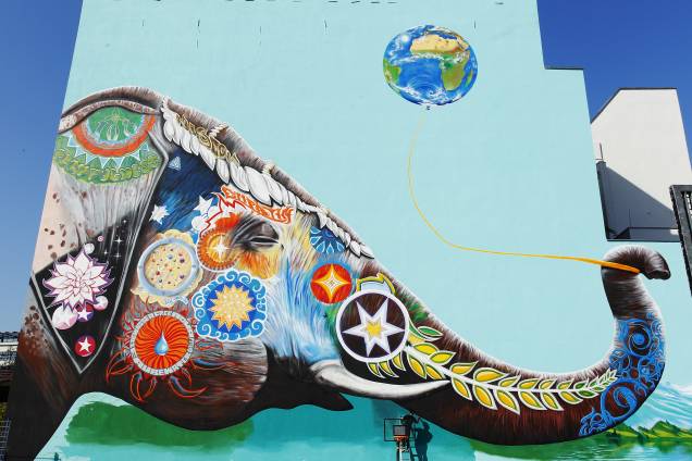 O artista alemão Jadore Tong faz os ajustes finais em um enorme mural com a imagem de um elefante colorido em Berlim, na Alemanha - 10/04/2017 O artista alemão Jadore Tong faz os ajustes finais em um enorme mural com a imagem de um elefante colorido em Berlim, na Alemanha - 10/04/2017