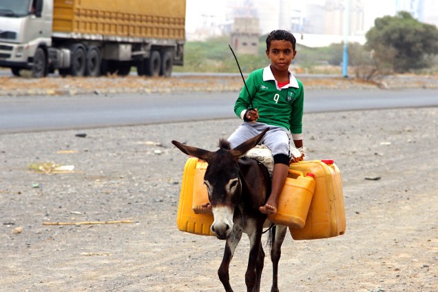 Menino montado em burro carrega água na cidade de Al Hudaydah, Iémen, que sofre com secas - 17/04/2017