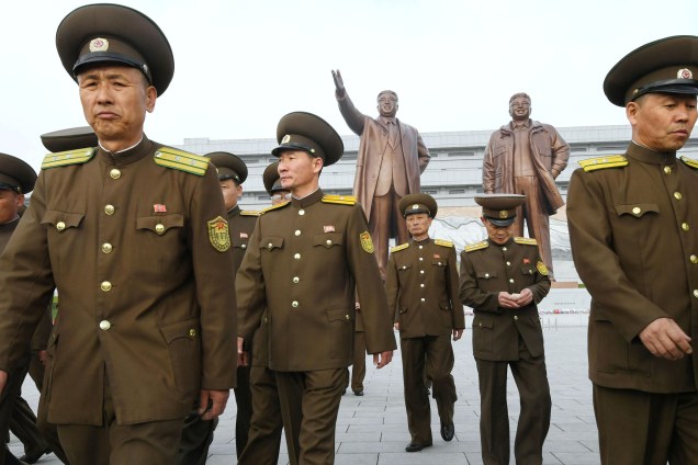 Militares norte-coreanos caminham na frente das estátuas de bronze do fundador da Coreia do Norte, Kim Il-sung, e do ex-ditador Kim Jong Il, em Pyongyang - 25/04/2017