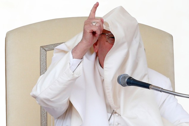 Papa Francisco fica com o rosto coberto com seu manto após uma rajada de vento durante a audiência geral na praça de São Pedro no Vaticano - 26/04/2017