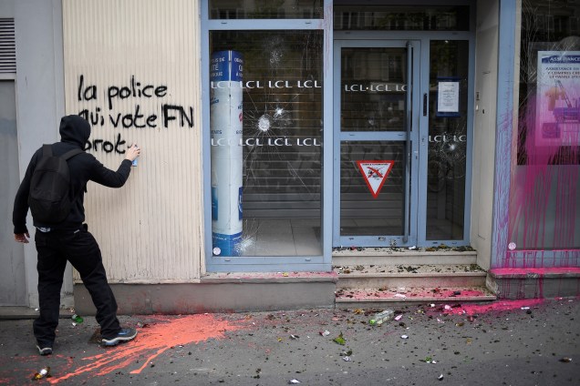 Homem faz uma pichação em ataque ao partido de extrema-direita Frente Nacional (FN), da candidata Marine Le Pen, durante manifestação contra os resultados do primeiro turno da eleição presidencial na França - 27/04/2017