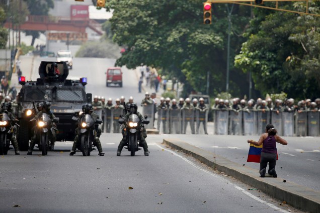 Manifestante fica de joelhos em frente a um contigente da polícia durante mais um protesto contra o presidente da Venezuela, Nicolás Maduro, em Caracas - 20/04/2017