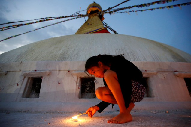 Menina acende uma vela em homenagem às vítimas do terremoto de 2015 em Katmandu no Nepal - 25/04/2017