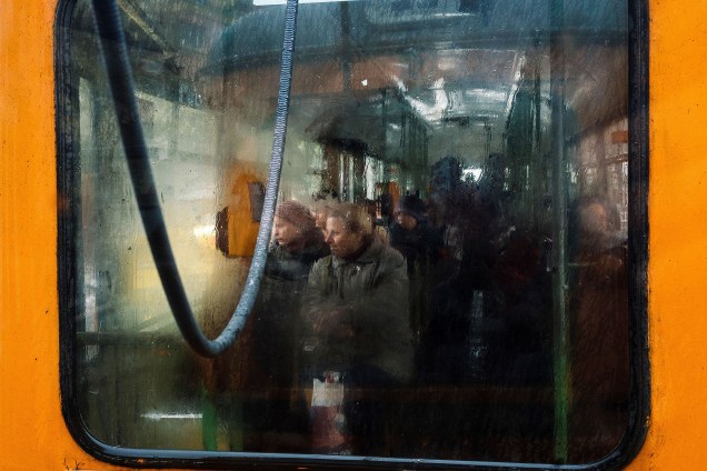 Pessoas observam por janela de trem durante manhã chuvosa e fria na região de Sofia, Bulgária - 20/04/2017