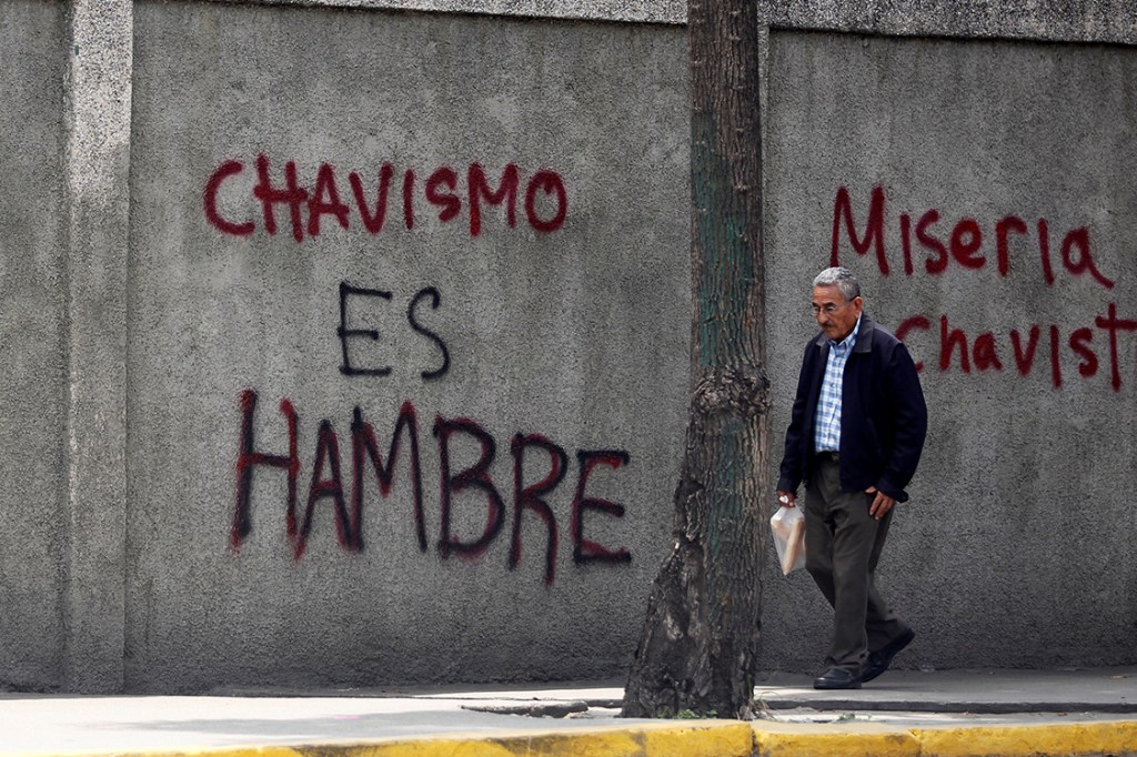 Manifestantes picham muros com dizeres "Chavismo é fome" durante protesto em Caracas, na Venezuela