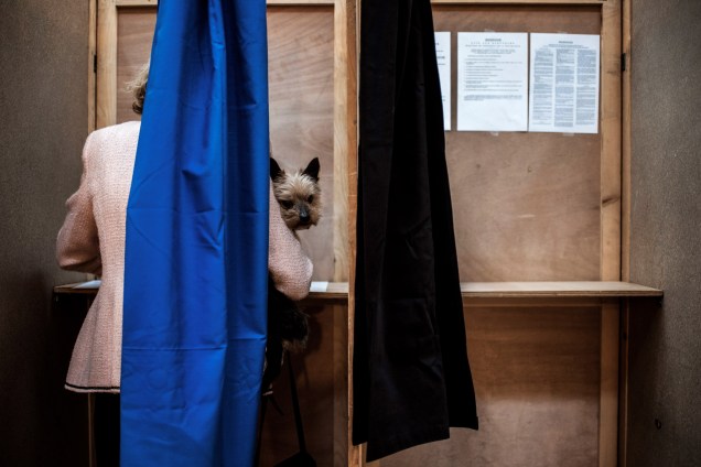 Mulher leva seu cachorro para votar em uma estação de voto em Lyon, na França - 23/04/2017