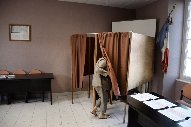 Mulher entra em uma cabine em uma estação de votação na cidade rural de Le Pin, leste da França - 23/04/2017