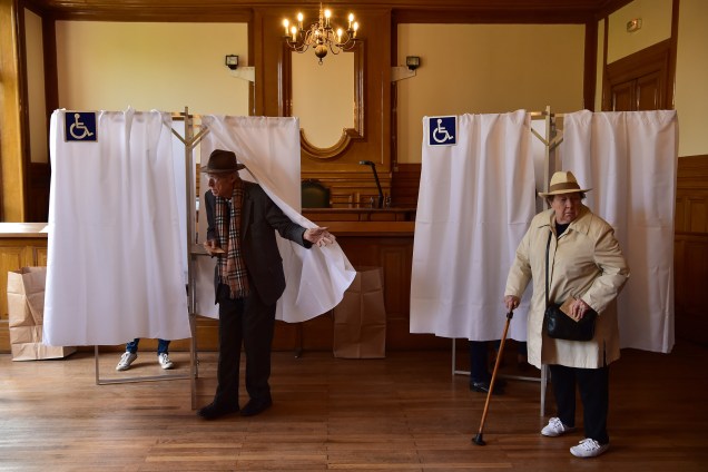 Eleitores deixam as cabines de voto em uma assembleia em Paris - 23/04/2017