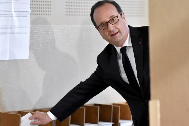 O presidente francês, François Hollande, recolhe as cédulas antes de votar em Tulle, região central da França - 23/04/2017