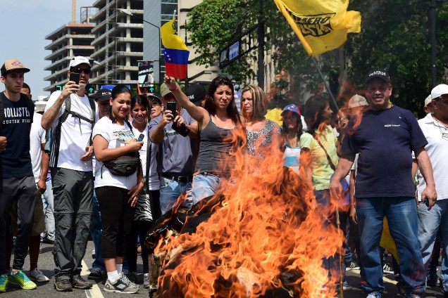 Manifestantes queimam um boneco representando o presidente venezuelano Nicolás Maduro durante um protesto de opositores em Caracas - 19/04/2017