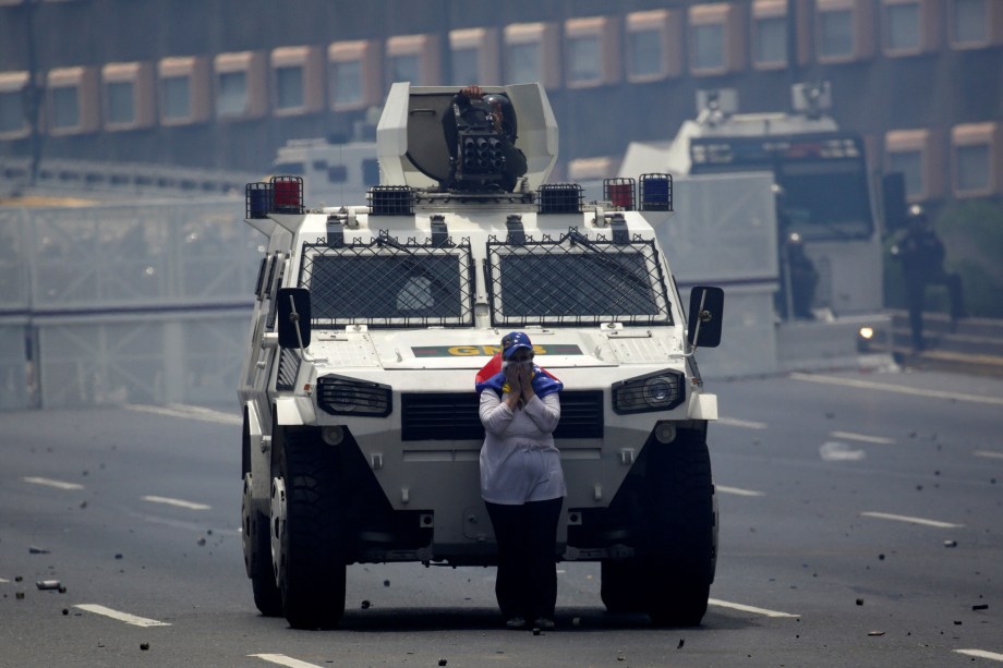 Manifestante de oposição bloqueia a passagem de um carro blindado durante protesto contra o presidente Nicolás Maduro em Caracas - 19/04/2017