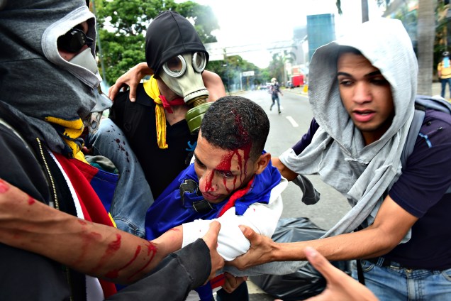 Manifestante ferido é carregado por outros manifestantes que protestavam contra o governo de Maduro, na Venezuela