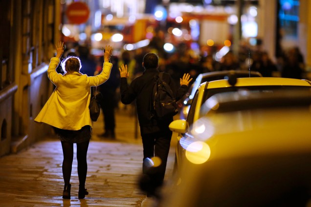 Mulheres levantam os braços para mostrar as mãos enquanto caminham em direção a polícia após tiroteio na  Champs Élysees, na França - 20/04/2017