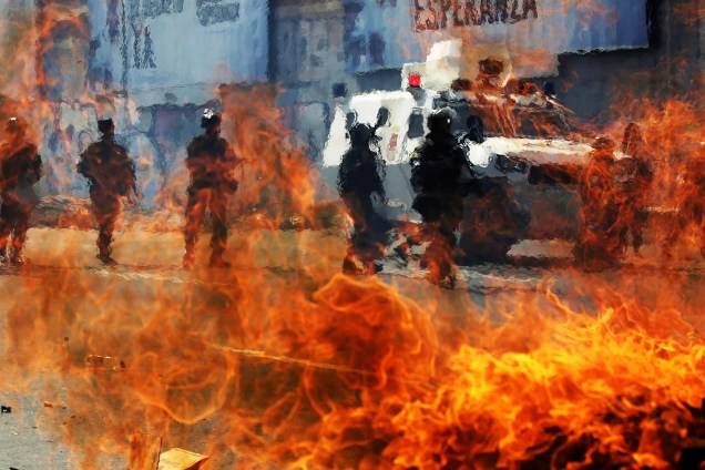 Guarda nacional venezuelana é fotografada atrás de um bloqueio em chamas durante os confrontos com os manifestantes da oposição durante um protesto em Caracas, Venezuela - 06/04/2017