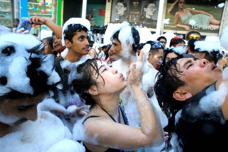 Foliões celebram o festival Songkran em uma festa de espuma em Bangcoc, Tailândia
