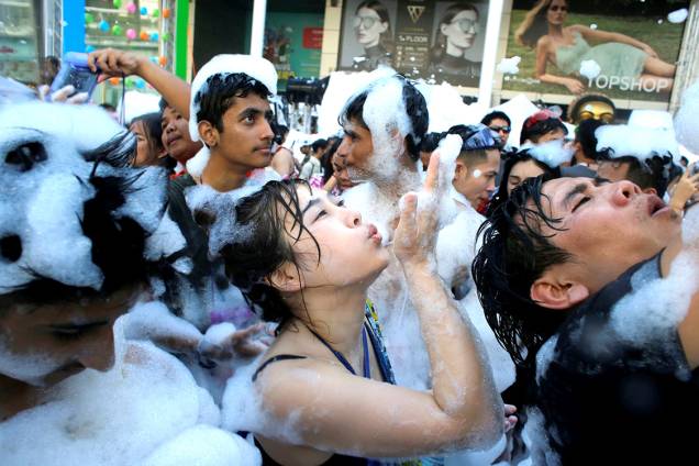 Foliões celebram o festival Songkran em uma festa de espuma em Bangcoc, Tailândia Foliões celebram o festival Songkran em uma festa de espuma em Bangcoc, Tailândia