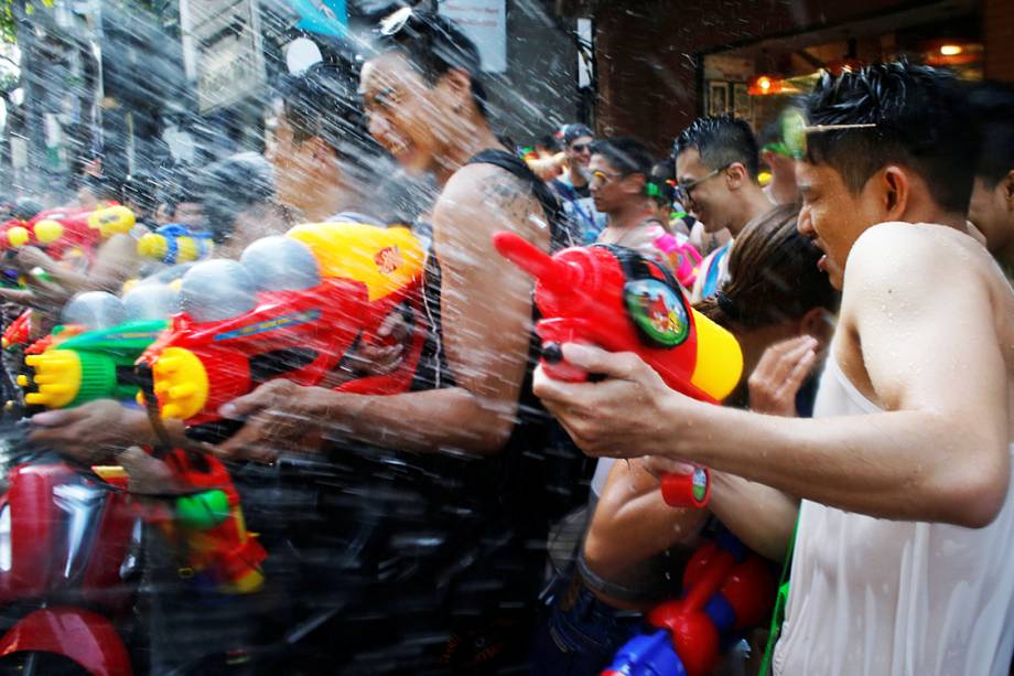 Foliões participam de uma "guerra" de água, durante o festival Songkran em Bangcoc, Tailândia