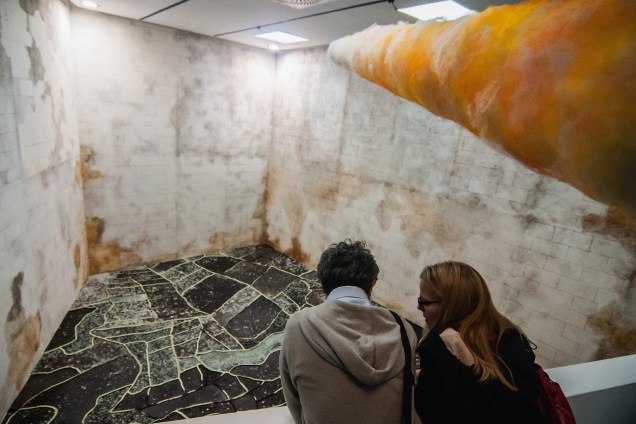 Visitantes observam a obra "Sun Stand Still", da artista Gal Weinstein, na Bienal de arte de Veneza que fica em cartaz até novembro